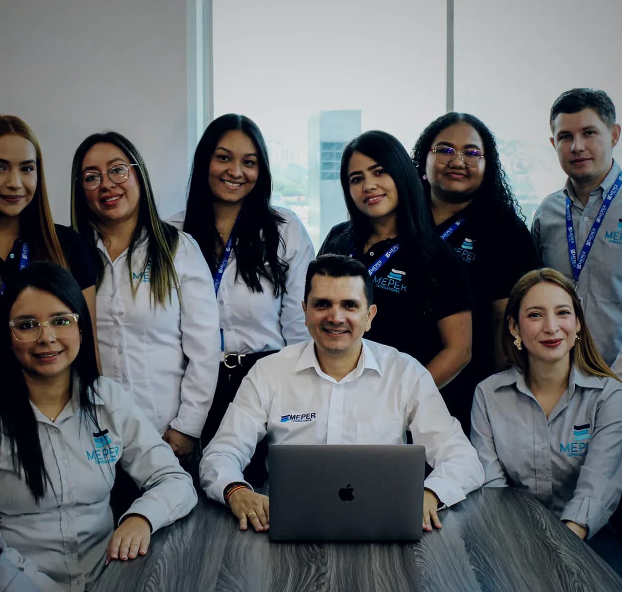 Equipo completo de MEPER Consultores reunido alrededor de su fundador en la sala de juntas